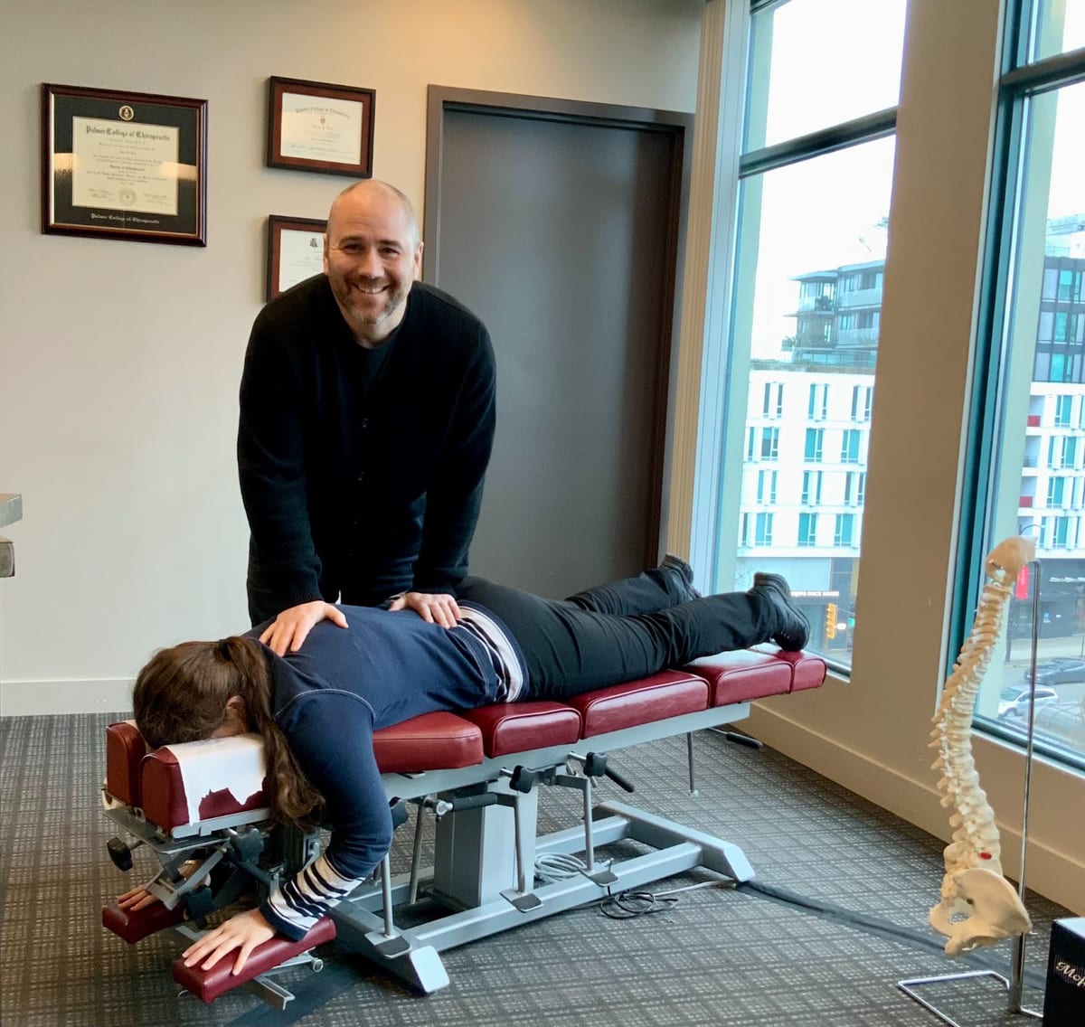 A chiropractor adjusting a patient's lower back on a drop table at In Touch Chiropractic
