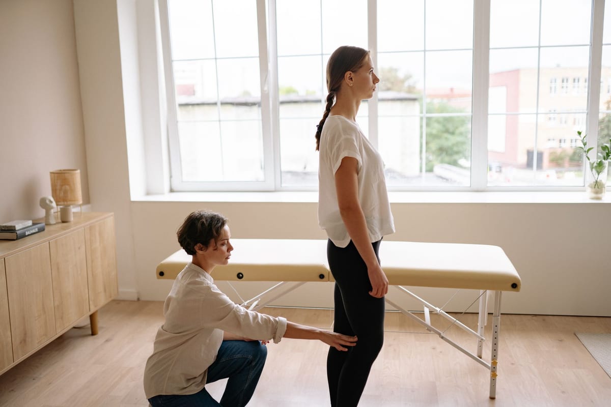 A practitioner assessing a standing patient's alignment
