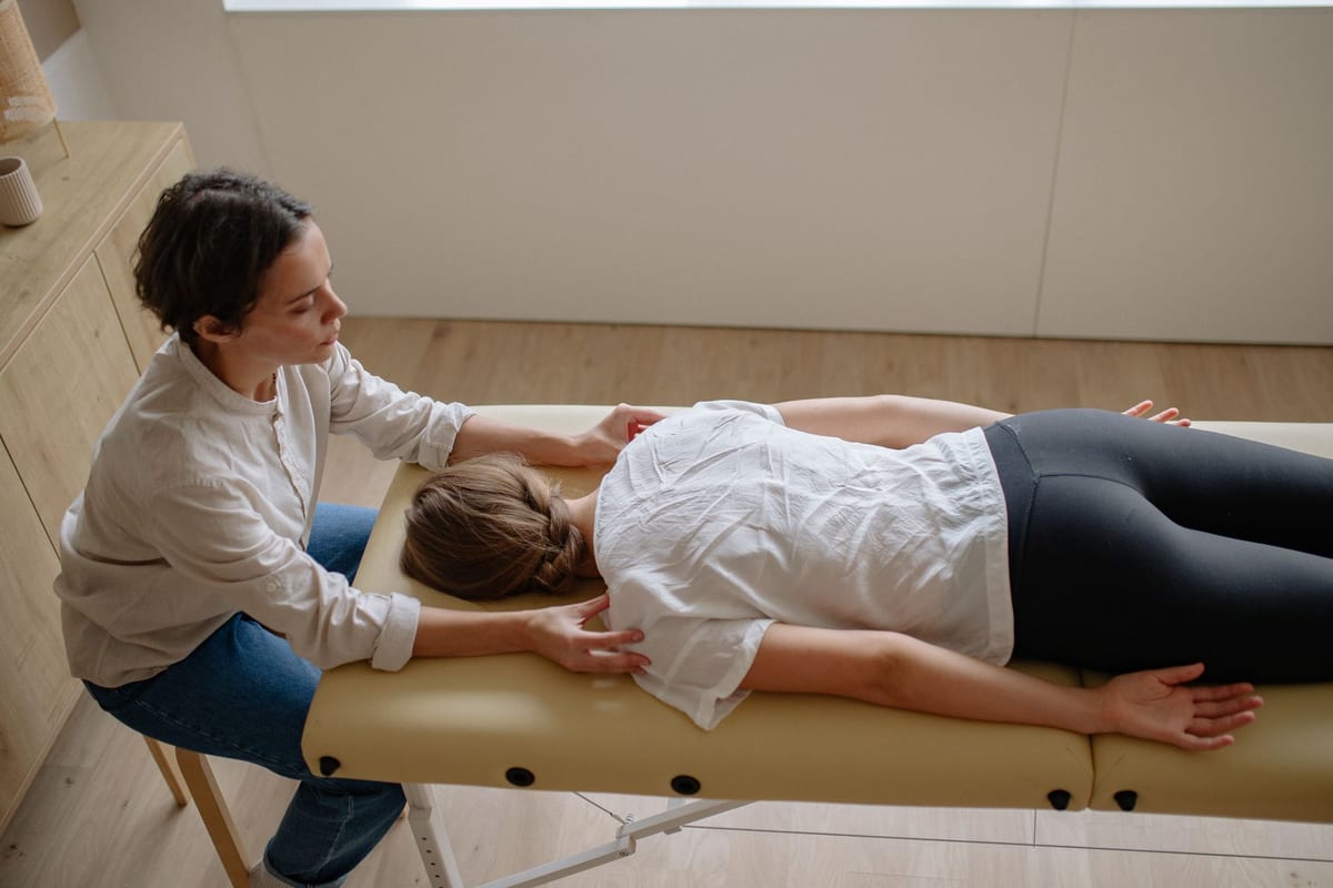 A clinician treating a patient's neck and shoulder